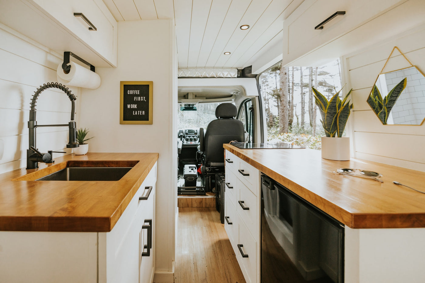Step inside this inviting RV rental with a modern kitchen, wood counters, black sink, and a fun "Coffee First" sign. — photo 4