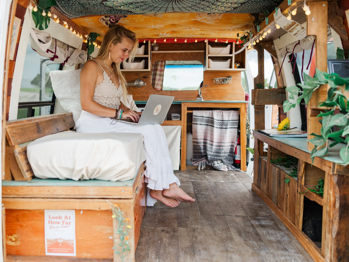  overlooking the ocean.|Adventure awaits! A woman with a surfboard jumps by her pink RV rental on a sandy beach — photo 4