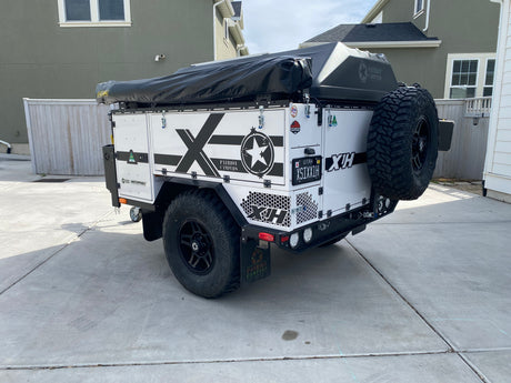 Rear view of a white Patriot Campers X1H off-road expedition trailer. Perfect for an outdoor RV rental adventure.