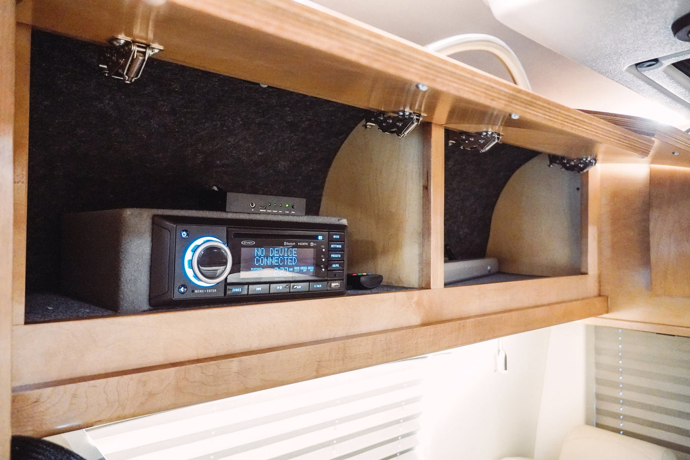 JENSEN Bluetooth stereo system in an RV rental's overhead cabinet, perfect for on-the-go entertainment. — photo 16