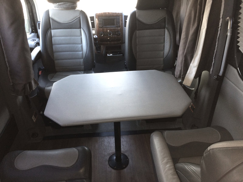 RV rental interior featuring comfortable front seats, a central table, and cozy rear seating. Ideal for travel! — photo 11