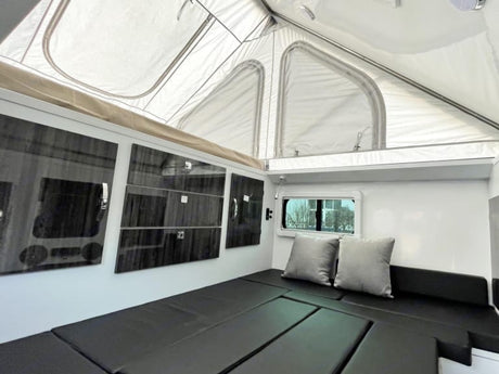  and mat on grass.|Explore with this RV rental: a pop-up camper trailer with an outdoor kitchen
