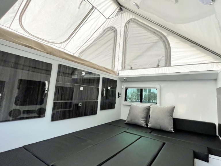  and mat on grass.|Explore with this RV rental: a pop-up camper trailer with an outdoor kitchen — photo 5