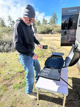 A man prepares to grill outdoors beside a Winnebago Solis RV, perfect for your next RV rental trip.