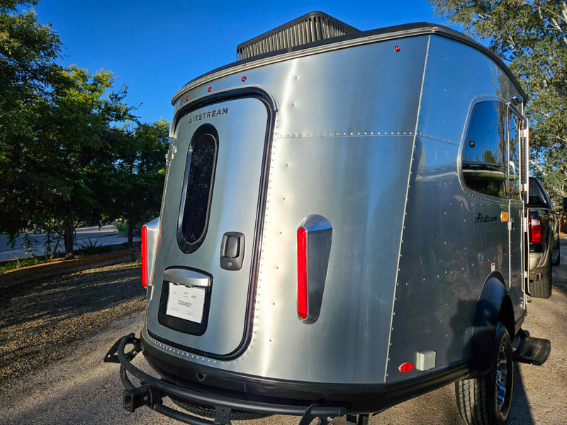 Rear view of a silver Airstream travel trailer, an ideal compact rv rental for outdoor adventures. — photo 9