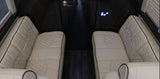 Inside an RV rental: Cream-colored, quilted seating and dark wood floors define this luxury interior with controls.
