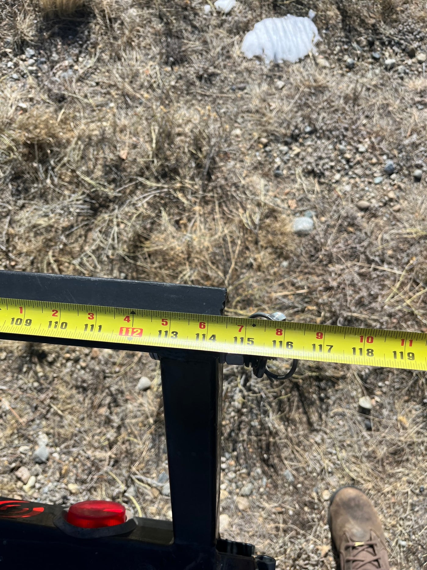 Measuring an RV rental component with a tape measure, showing inches from 109 to 119 on a metal beam. — photo 5