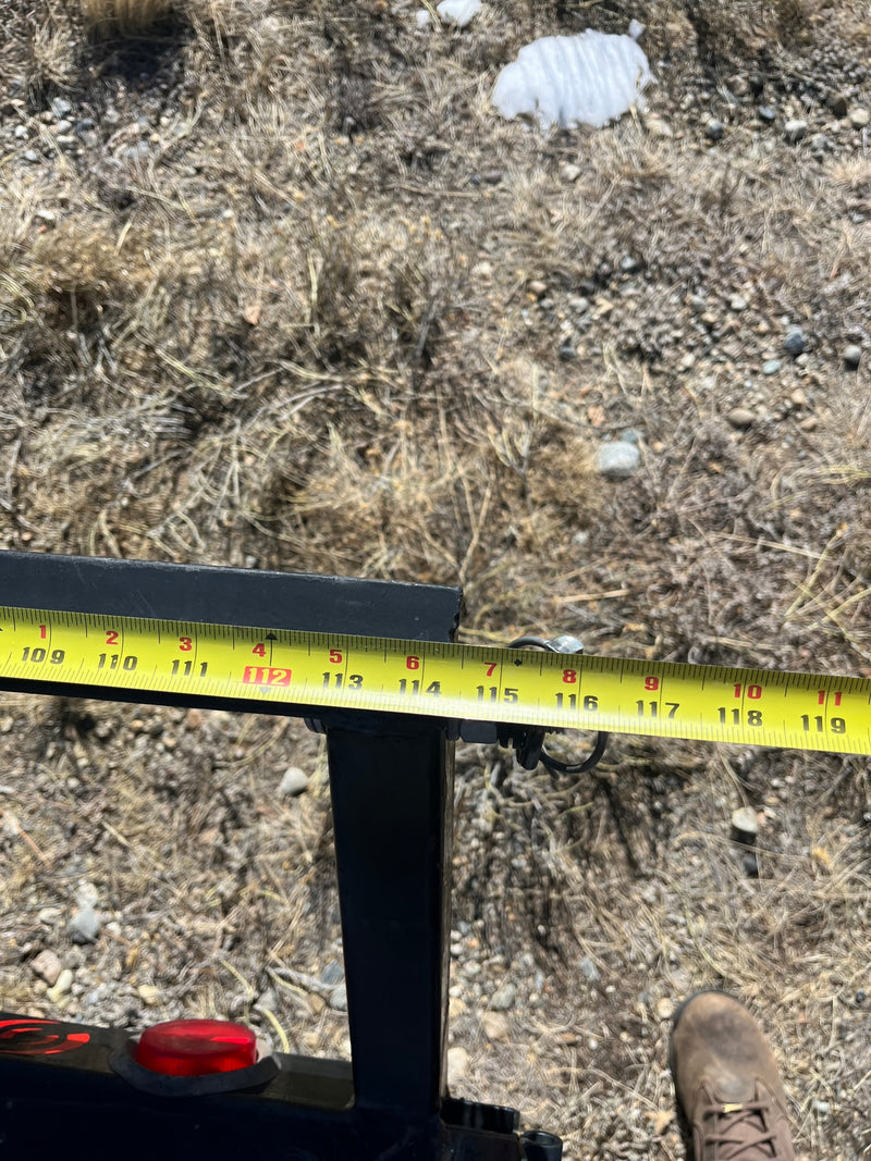 Measuring an RV rental component with a tape measure, showing inches from 109 to 119 on a metal beam. — photo 5
