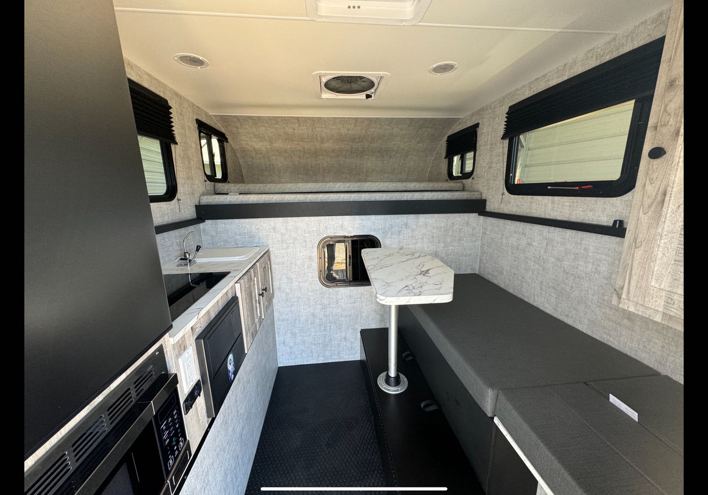  ready for adventure.|Experience nature with an RV rental: a robust truck camper parked on a dirt road among tall pine trees — photo 12