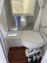 This RV rental bathroom features a compact wet bath with a raised toilet, integrated shower, and sleek storage for toiletries.