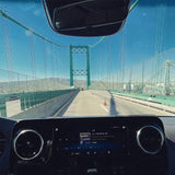 Driving an RV rental on a sunny day! Dashboard view of a green suspension bridge and 101.1 FM radio. A great road trip.