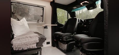 Spacious RV rental interior featuring a cozy seating area, adjustable table, and front cabin. Perfect for your mobile living adventure.