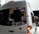 An Airstream Interstate rv rental's rear window, covered in ski resort and outdoor brand stickers from various adventures.