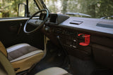 Step inside this cozy VW van! A detailed view of the driver's seat, dashboard, and controls for your RV rental journey.