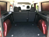 Looking into the spacious cargo area of an RV rental, featuring rear seats, side storage, & floor tie-downs.