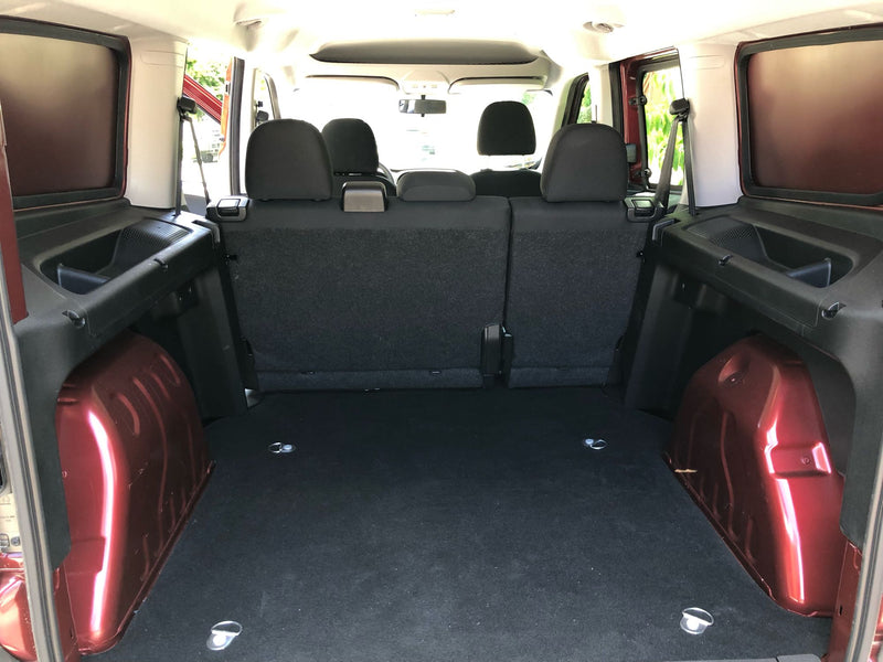 Looking into the spacious cargo area of an RV rental, featuring rear seats, side storage, & floor tie-downs. — photo 10