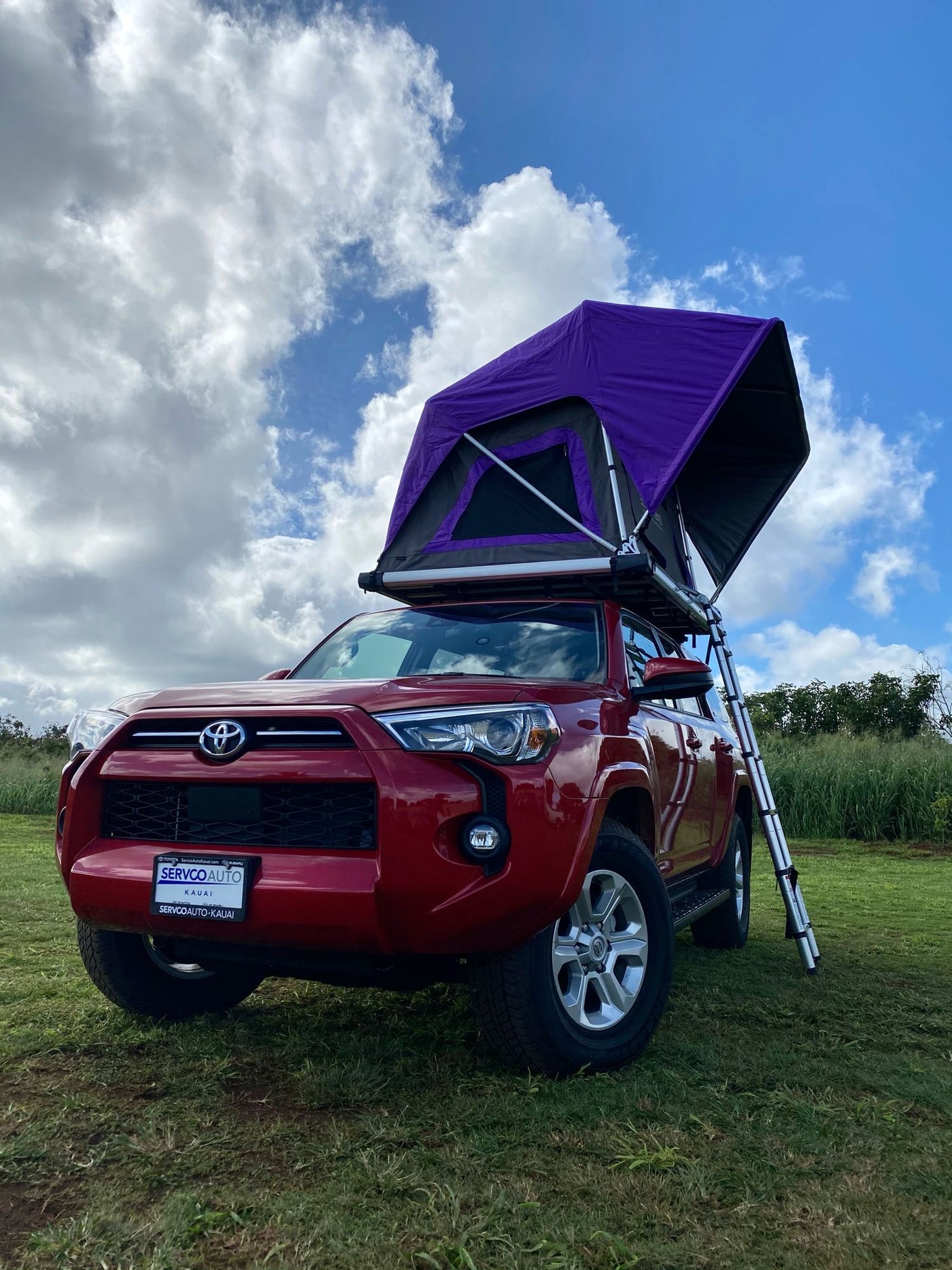 Red SUV with purple rooftop tent deployed, ready for **RV rental** camping adventures on Kauai. — photo 2