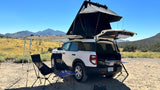 Explore the outdoors! This Bronco Sport RV rental is set for car camping with a rooftop tent, awning, & pull-out kitchen in a desert.