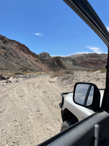 View from an off-road vehicle on a rocky desert trail, surrounded by colorful mountains. Ideal for an RV rental adventure.