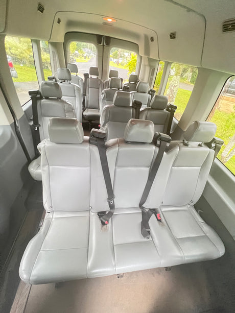 Spacious grey passenger van interior, great for group travel or RV rental excursions. Features multiple rows of comfortable seats with seatbelts.