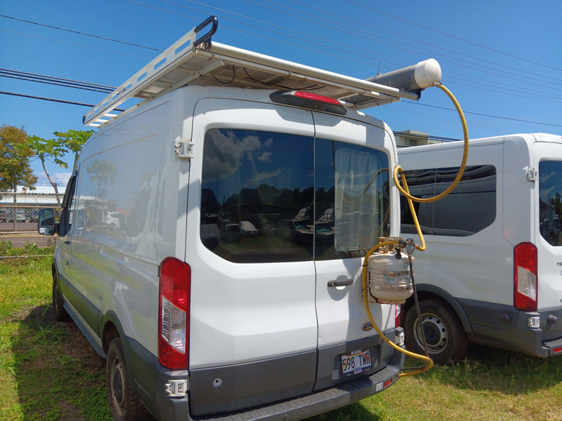Modified white Ford Transit van, potentially an rv rental, with a roof rack, solar panel, water, and propane tanks. — photo 14