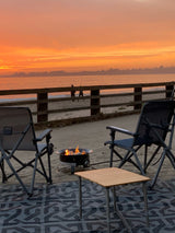 Relaxing beach camp with fire pit, chairs, & stunning sunset. Ideal rv rental getaway for ocean views.
