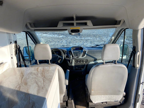 Interior view of a camper van for rv rental, showing the front cabin, dashboard, and a built-in counter.