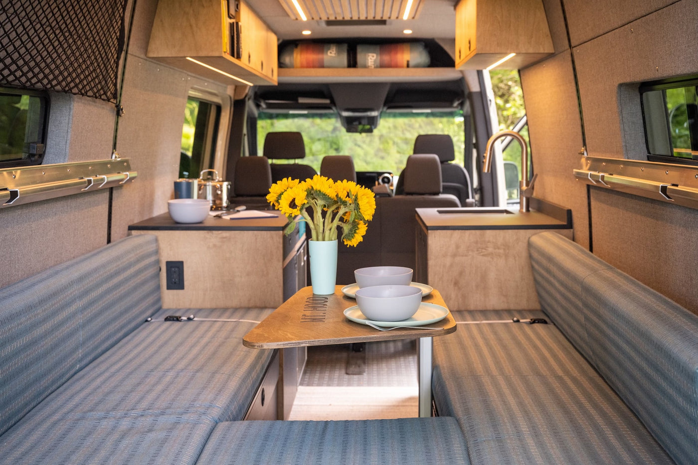 Inside a stylish RV rental with dining table, kitchen, and cozy bench seating. — photo 20