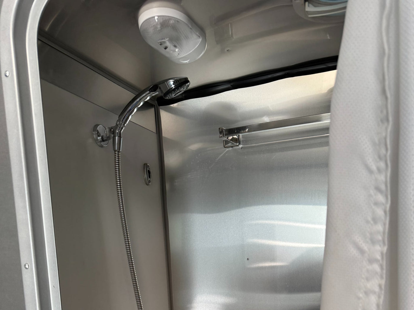  and door storage.|Modern RV rental kitchen counter with covered sink/stove — photo 5