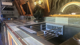 RV rental kitchen: compact sink with drying rack, fan, cooktop, and tiled counter. Ready for your mobile adventures.