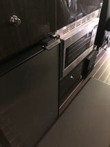 Inside an RV rental: Compact kitchen featuring a Nova Kool refrigerator and built-in oven/microwave.