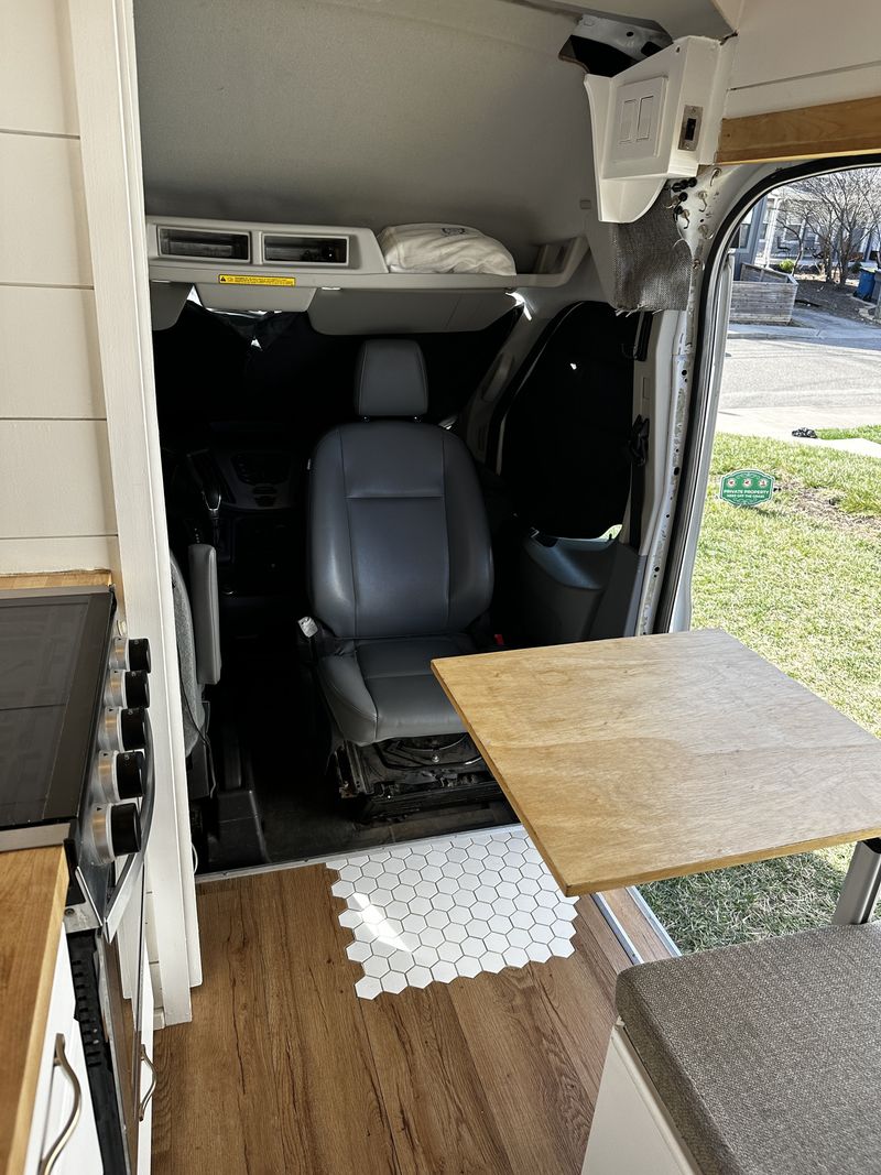  and cozy bed area.|Inside an **RV rental**: a built-in outdoor shower hose in a drop-down compartment. Kitchen and ample storage are also visible.|Comfortable RV rental camper van interior. Features a bed — photo 11