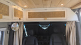 RV rental interior showcasing custom rattan overhead cabinets, wood ceiling, and privacy curtains separating the cab.