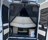 Rear view of an RV rental camper van with open doors, revealing a mesh insect screen, bed, and under-bed storage.