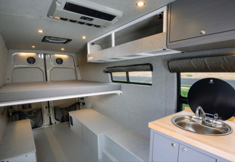 RV rental: Modern camper van interior featuring elevated bed, kitchenette, and versatile storage. — photo 6