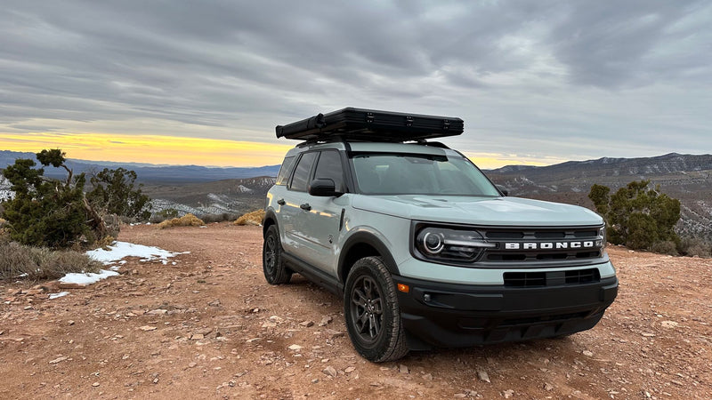  a unique RV rental alternative for scenic overlanding in the mountains.|A Ford Bronco Sport with rooftop tent on rugged terrain. Perfect for scenic outdoor adventure. Consider an RV rental for your next trip.|A grey Bronco Sport with a rooftop tent & awning — photo 17