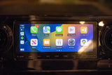 Inside an RV rental: Apple CarPlay infotainment system showing navigation, communication, and entertainment apps.