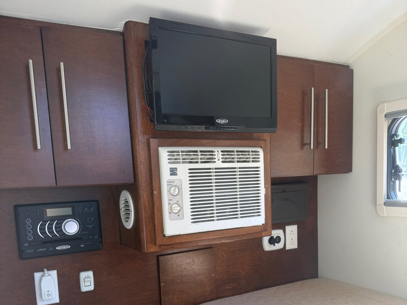  and wood cabinets.|This RV rental teardrop trailer shows an outdoor kitchen with a stove — photo 6