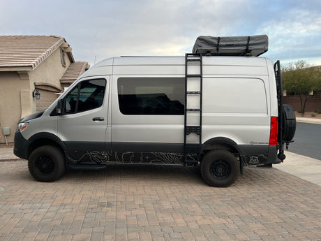 This customized silver Sprinter van with a rooftop tent is ready for your next RV rental adventure.