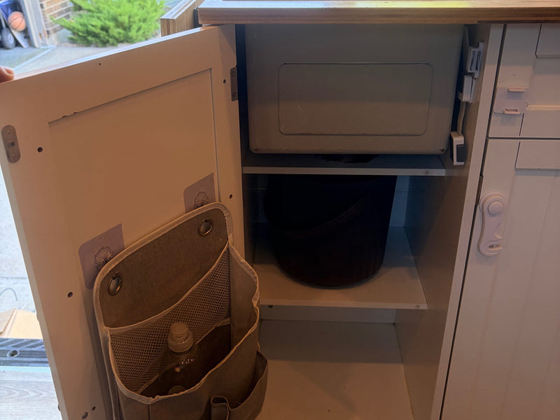  and side storage units.|Cozy RV rental interior featuring a compact kitchen with an induction cooktop — photo 7
