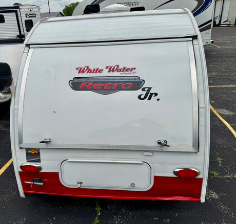 Rear view of a white and red White Water Retro Jr. travel trailer, great for an RV rental adventure.