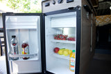 An open RV rental fridge, neatly packed with fresh fruit, kombucha, and juice. Ready for your next adventure!