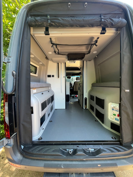 Clean, spacious rv rental camper van interior. Rear view showing beds & aisle, perfect for travel.