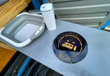 RV rental cooking setup: collapsible sink, portable water dispenser, and induction cooktop for easy camping meals.