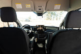 Inside a Ford RV rental van, showing the dashboard, steering wheel, and front cabin with a view of the outdoors.