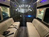 RV rental interior: Plush beige seating, a central TV, and wood-look floor create a luxurious mobile lounge.