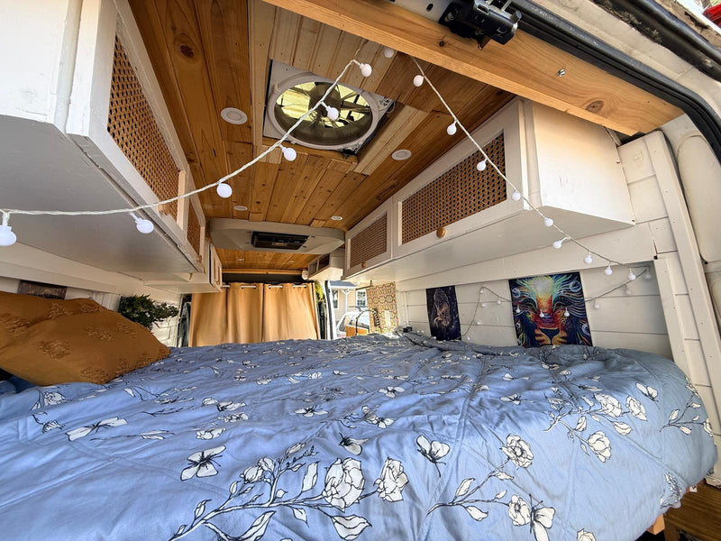  parked on a city street beside a building with a floral mural.|Cozy rv rental interior — photo 4