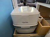 Essential white Porta Potti portable toilet in an RV rental, ensuring comfortable travel and sanitation.