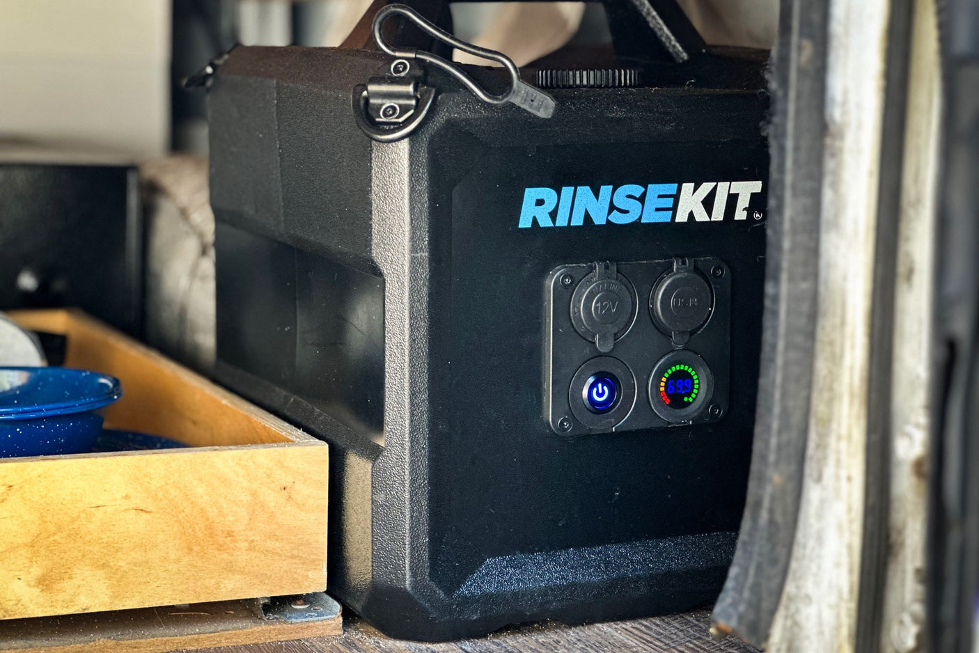 Black RINSEKIT portable power station, showing 69.5% charge, useful for any RV rental or camping trip. Features 12V and USB ports.