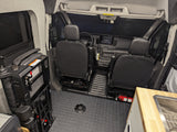 Interior of an RV rental van showing front seats, dashboard, and a deployed wheelchair lift for accessible travel.
